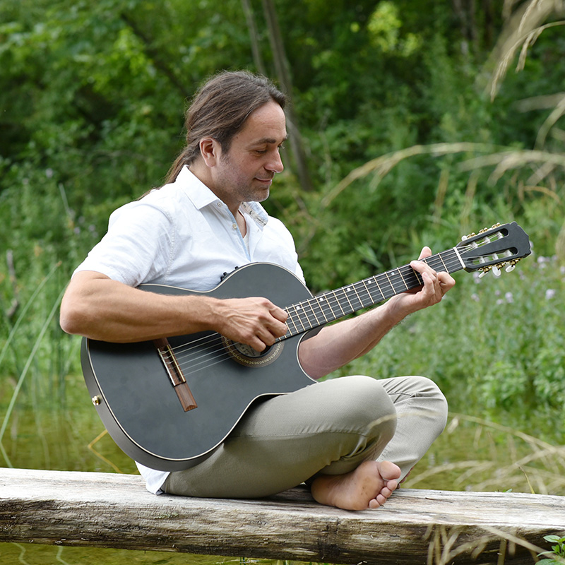 Martin Regnat Portrait Martin mit Gitarre auf dem Steg